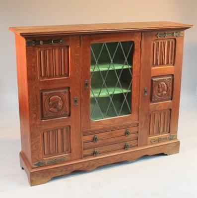 A 20thC oak linen-fold display cabinet with astragal glazed panel