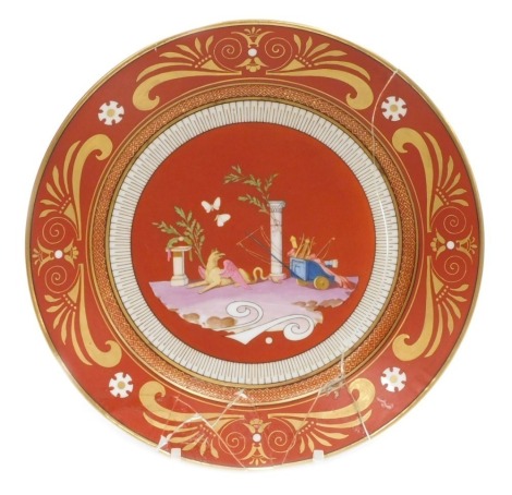 A mid 19thC Sevres Etruscan red ground hard paste porcelain dessert plate, decorated with a griffin, Roman chariot, columns and butterflies, within a stylised gilt anthemion leaf and scroll border, Napoleon crowned 'N' mark in iron red, 24cm diameter (AF)