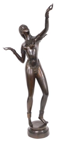 A late 20thC bronze figure of an exotic dancer, adorned with a jewelled necklace and G string, her arm outstretched, on a circular base, 95cm high.