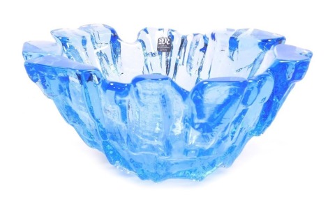 A late 20thC Mats Jonasson blue glass bowl, of abstract, ice formation form, marked to base Mats Jonasson Sweden, bears paper label, 20.5cm wide.