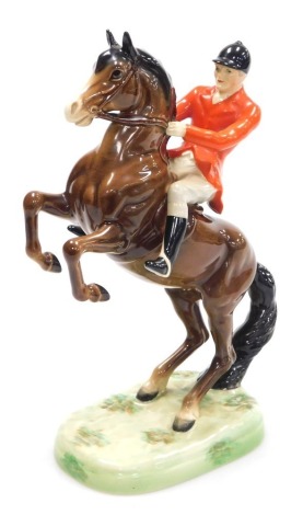 A Beswick pottery figure of a huntsman on a rearing horse, brown gloss, raised on a naturalistic base, number 868, printed and impressed marks, 25cm high.