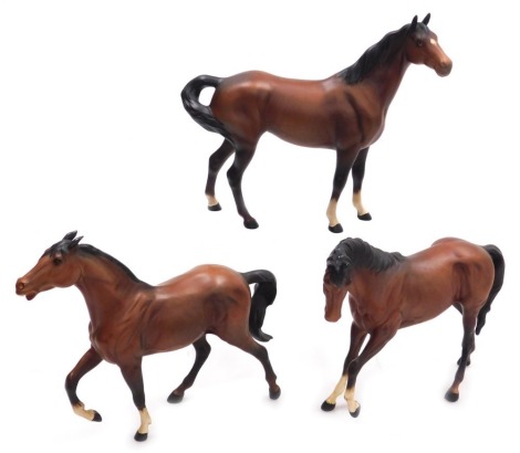 Three Beswick matt brown pottery figures of horses, in various poses, printed marks.