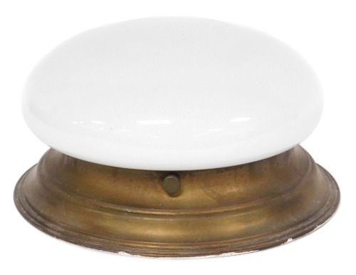 An early 20thC milk glass ceiling light, with a brass coated circular tin mount, 29.5cm wide.