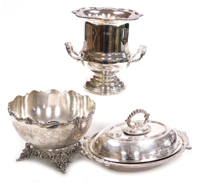 Plated wares, comprising a twin handled wine cooler, circular fruit bowl with engraved decoration, raised on a pierced and scrolling foliate foot, and a Victorian silver plated entree dish and matched cover. (3)