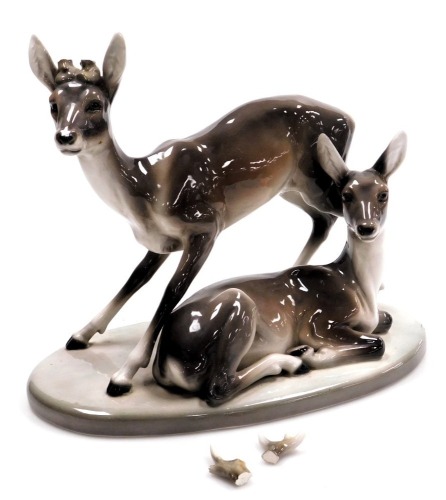 A Goldscheider Art Deco figure of two deer, model number 4760/49/6, artist initial F, 29cm high, 37cm wide. (antlers missing)