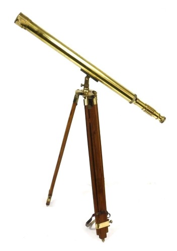 A brass cased telescope, on a wooden tripod stand, telescope 99cm long.