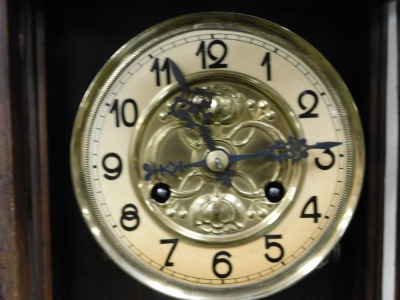 A late 19thC Vienna mahogany cased wall clock, circular brass dial embossed with flowers, chapter ring bearing Arabic numerals, eight day movement with coil strike, the triple urn topped pediment carved centrally with a lion's head mask, the case with arc - 2