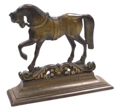 A Victorian brass doorstop, cast as a prancing horse, on a foliate scroll ground, above an outswept base, 30cm wide.