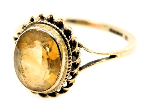 A 9ct gold and citrine ring, oval cut, in a high claw setting size O, 2.3g.