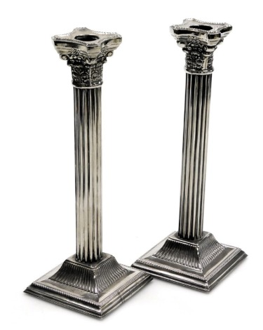 A pair of silver plated Corinthian column candlesticks, with stepped square bases, stamped Made in England, 25.5cm high.