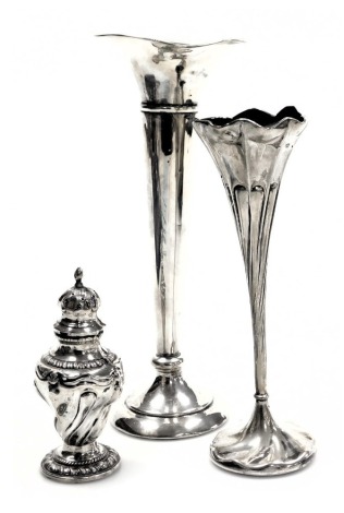 An Edward VII loaded silver bud vase, of trumpet form, Birmingham 1906, 20cm high, further bud vase of spiral fluted form, Sheffield 1906, 16.5cm high, and a fluted silver pepperette, Birmingham 1906, 10.80oz all in. (3)