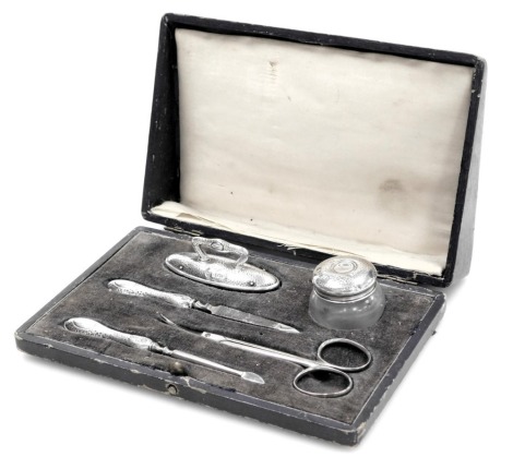 A George V silver, steel and glass five piece manicure set, with stipple engraving, oval shield reserve, cased, Birmingham 1926.