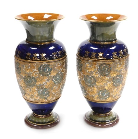 A pair of Royal Doulton stoneware vases, of baluster form, chine decorated with honeysuckle, within a blue and olive ground, impressed marks, 34.5cm high.