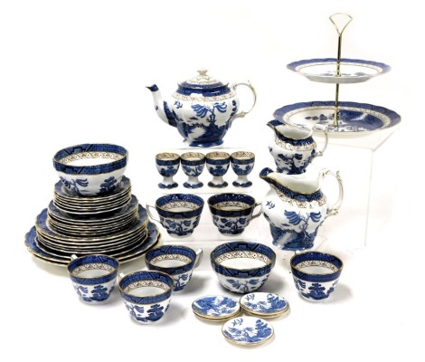 A Booths pottery Real Old Willow pattern tea/breakfast service, comprising tea pot cream and milk jugs, four egg cups, two tier cake plate, pair of graduated sugar bowls, six tea cups, saucers and plates, six breakfast plates, and two bread plates, togeth