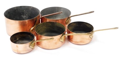 A graduated set of five copper vintage saucepans.