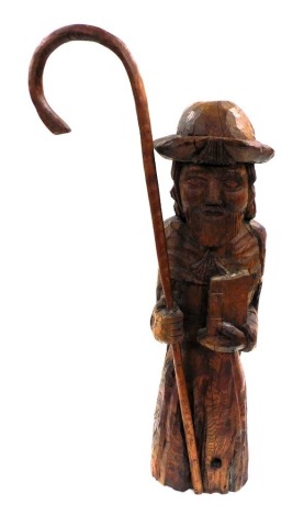 A 20thC European carving of a religious gentleman, modelled standing holding a shepherd's crook and a book, 61cm high.