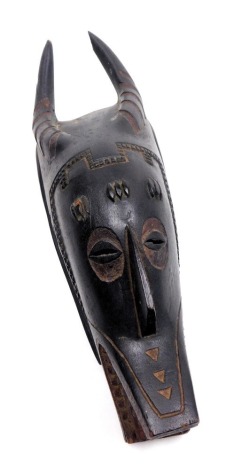 A Burkina Faso or Ivory Coast wooden mask, of a horned figure, 47cm high.