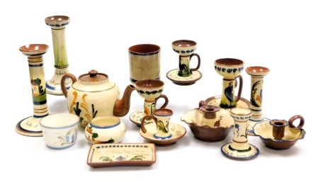 A group of early 20thC Devon Motto Ware pottery, including candlesticks, chamber sticks, a teapot and sugar bowl. (a quantity)