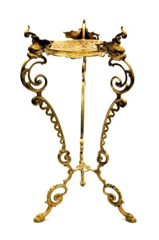 A 20thC brass plant stand, raised on three dolphin capped scrolling supports, 60cm high.