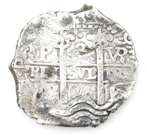 A silver coin, possibly a Peruvian Carlos II eight Reals coin.