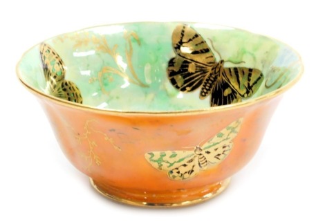 An early 20thC Aynsley porcelain butterfly lustre bowl, decorated internally with three cobalt blue and gilt butterflies and a central floral motif, against a mottled green ground, externally with cobalt blue and green butterflies against an orange ground