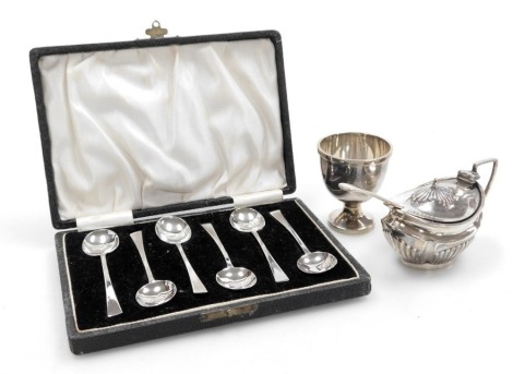 An Elizabeth II silver egg cup and spoon, Sheffield 1957, Edward VII silver mustard pot of semi fluted form, with clear glass liner, Sheffield 1904, and six George V silver coffee spoons, cased, Birmingham 1931, 4.07oz.