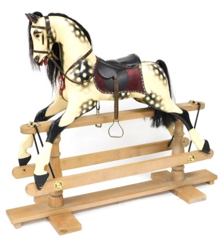 A Giddy Up dappled grey rocking horse, raised on a light oak base, 128cm high, 152cm wide.