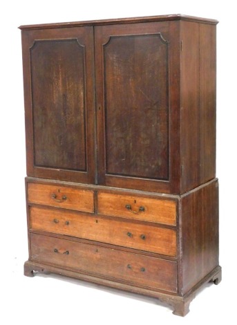 A George III oak linen press, the pediment over a pair of doors opening to reveal an interior converted to a hanging space, above two short over two long drawers, raised on bracket feet, 184cm high, 127cm wide, 61cm deep.