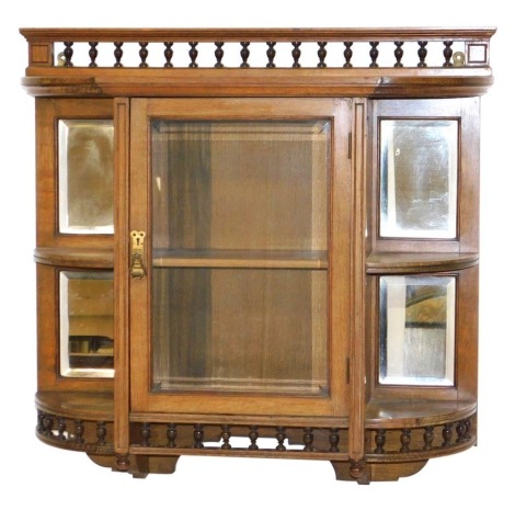 A Victorian oak wall mounted display cabinet, with a galleried top over a central glazed door, inset bevelled glass, enclosing a shelf, flanked to the sides by glass backed quarter shelves, above a galleried apron, 70cm high, 75cm wide, 20cm deep