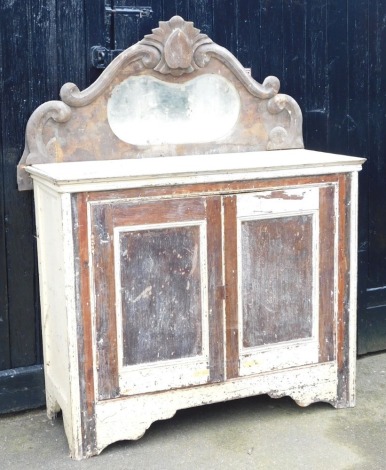 A Victorian stained and cream painted pine chiffonier, with a foliate carved mirror, inset bevelled glass, above a pair of doors, enclosing a single shelf, raised on bracket feet, 171cm high, 124cm wide, 49cm deep.