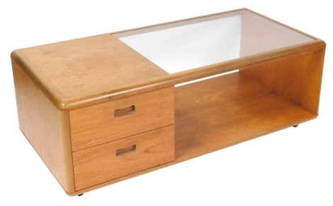 A mid century teak coffee table, the top inset with a rectangular glass plate, above two drawers and a drinks cabinet, flanked by a recess, on castors, 44cm high, 121cm wide, 59cm deep.