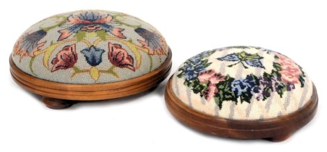 Two circular beech footstools, with overstuffed wool work upholstery, embroidered with flowers and a butterfly in a framed circular floral wreath, 31cm diameter and 26cm diameter.