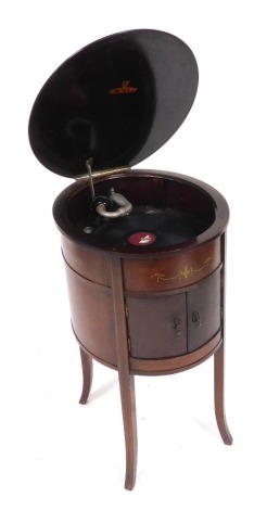 An Edwardian Academy table gramophone, the case of oval cylindrical form, raised on four outswept legs, 82cm high, 56cm wide, 48cm deep.