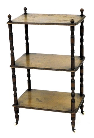 A Victorian oak three tier whatnot, raised on turned supports, brass capped on castors, 83cm high, 51cm wide, 36cm deep.