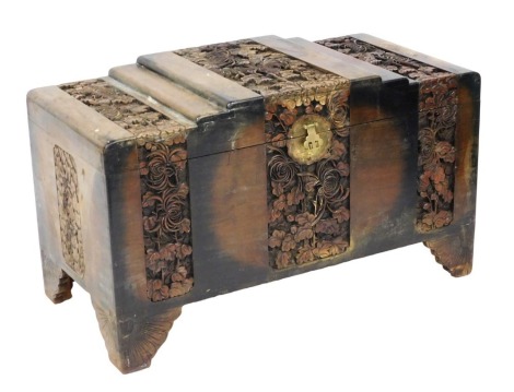 An early 20thC Chinese camphor wood chest, with a stepped lid, profusely carved with bands of flowers and leaves, raised on bracket feet, 60cm high, 101cm wide, 51cm deep.