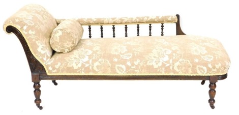 A Victorian mahogany framed chaise longue, with a galleried side, upholstered in brown and white foliate fabric, raised on turned legs on castors, 175cm wide.