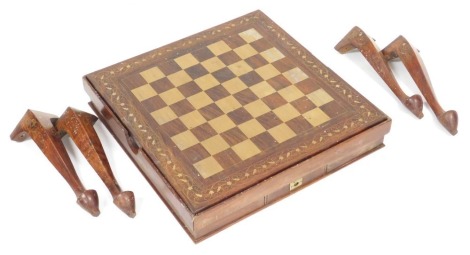 An Eastern hardwood and brass inlaid games table, reversible, with a chequer board top, above two frieze drawers, raised on cabriole legs, 49cm high, 63cm wide, 64cm deep.