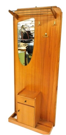 A mid century Entryway teak hall stand, with metal rails, shaped mirror and fixed pegs, above cupboard and drawer on plain base, 184cm high, 82cm wide, 26cm deep.