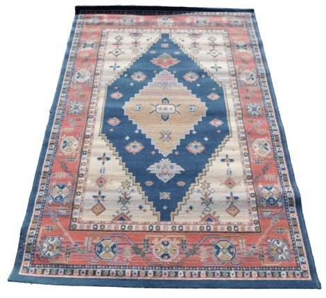 A Turkish blue and cream ground rug, decorated with stylised floral motifs, within repeating floral borders, 194cm x 133cm.