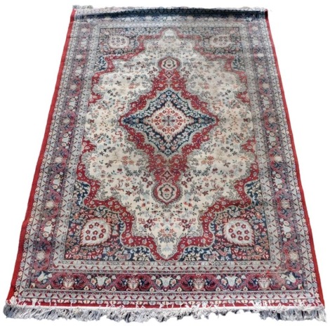 A Heriz cream ground rug, with a central floral decorated medallion, within a cream field of further flowers, and repeating floral and geometric borders, 270cm x 192cm.