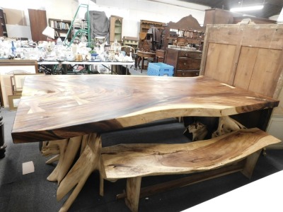 A large tree root table, the rectangular top raised on two tree root supports, 80cm high, the top approx 122cm x 260cm, together with two benches, each 47cm high, 196cm wide. - 4