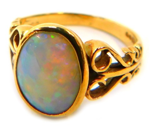 A 9ct gold opal dress ring, the oval opal in a rub over setting, with scroll design shoulders, ring size P, 3.5g all in.