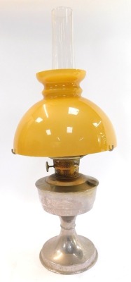 A 20thC oil lamp, with yellow glass shade above a chrome base, with chimney, 60cm high, together with a further brass oil lamp base, two glass chimneys and a moulded glass shade. - 2