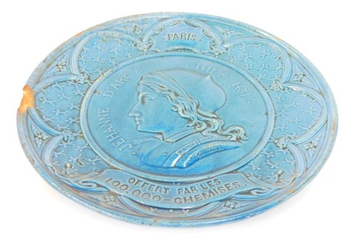 A late 19thC French relief moulded plate, bust of Joan of Arc, a titled reserve "of Paris", above a banner "Offert Par les 100,000-Chemiscs", in a border of fleur-de-lys, 29cm diameter. (AF)