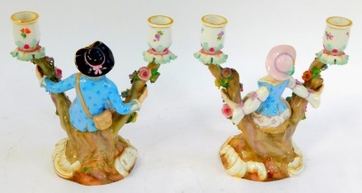 A pair of late 19thC Meissen porcelain candelabra, modelled as a gallant and lady, seated within a tree, encrusted with flowers, raised on a rococo scroll base, incised numbers 1129 and 1130, painted marks, 20cm high. - 2