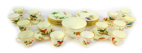 A late 19thC Royal Worcester porcelain part tea service, decorated with birds and flowers, against a white ground of gilt highlights, dated 1880, printed marks to underside, comprising sugar bowl, fourteen cups, four saucers, and twelve tea plates.