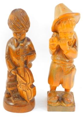 Two carved treen figures, depicting a child playing a cello, 33cm high, and a child playing a piccolo, 35cm high.