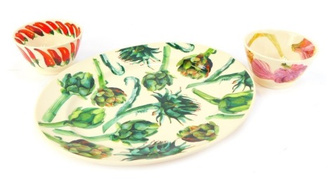 A group of Emma Bridgewater pottery from the Vegetable Garden series, comprising an oval platter in the Artichoke pattern, 36cm wide, and two small bowls decorated with garlic and chilli, 12.5cm diameter. (3)