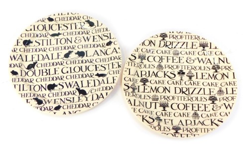 Two Emma Bridgewater pottery Black Toast pattern platters, decorated with cakes and cheeses, 33.5cm diameter.