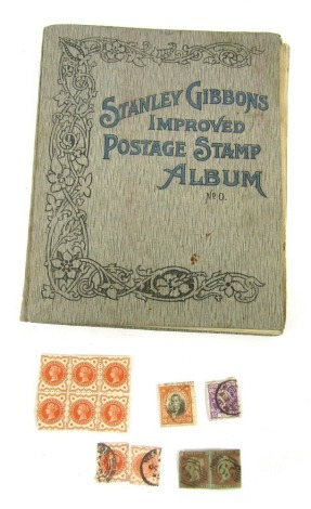 A Stanley Gibbons Improved Postage Stamp Album, containing GB and world stamps for Ceylon, Switzerland, German Empire, together with two loose penny red stamps, Victorian Postage and Revenue one half penny stamps, etc.